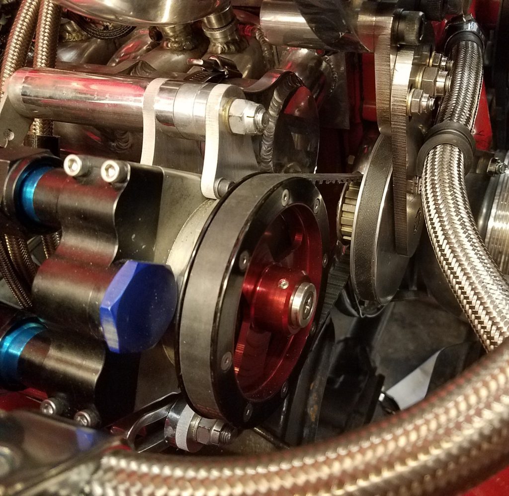 Photo showing the Star Machine vacuum pump installed on the engine with its belts and tensioner.